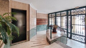 A modern staircase with a handrail, a potted plant, and a decorative metal gate. - 2 bedroom stunning apartment in Nerja (Nerja)