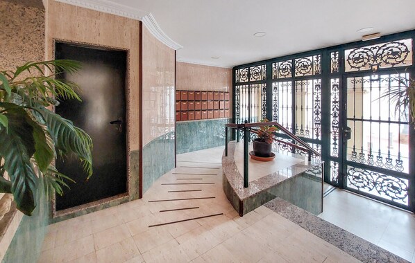 A modern staircase with a handrail, a potted plant, and a decorative metal gate. - 2 bedroom stunning apartment in Nerja (Nerja)