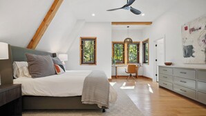 Ein Schlafzimmer mit Bett, Schreibtisch und Blick ins Freie.