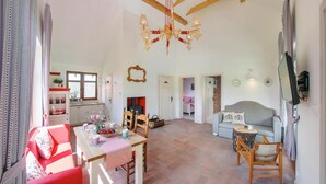 A spacious living area with a wooden dining table, a grey sofa, and a television mounted on the wall. - 2 bedroom beautiful home in Krzeszna (Krzeszna)