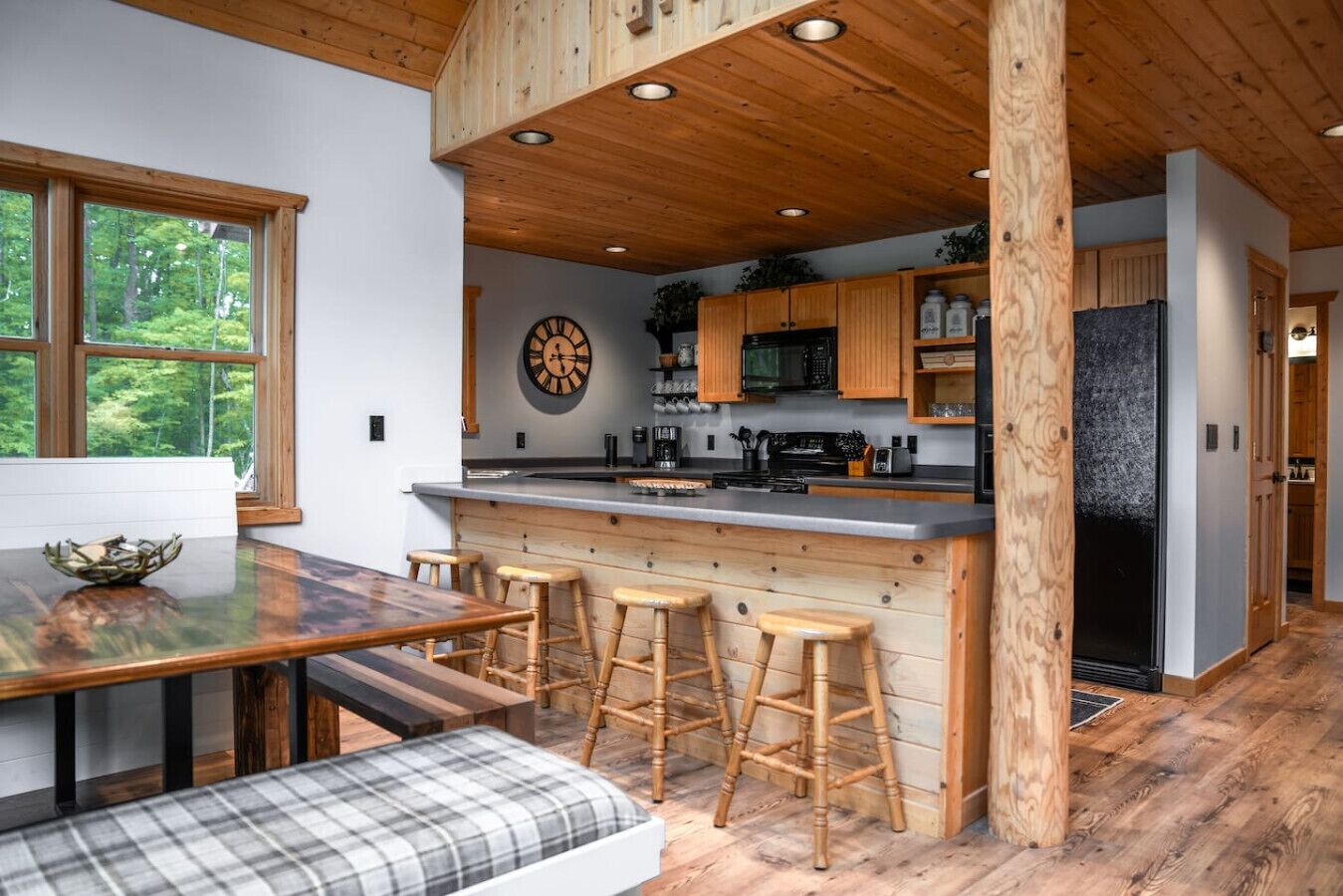 Une cuisine moderne agrémentée d’éléments en bois, un coin bar et un espace repas avec un banc.