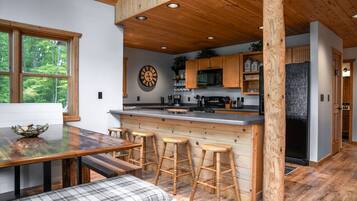 Une cuisine moderne agrémentée d’éléments en bois, un coin bar et un espace repas avec un banc.