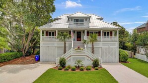 A two-story house with a front porch, a staircase, and a well-maintained lawn. - Be a Sullivans Local! 1307 Cove Avenue by Avantstay Pool + Outdoor Living (Sullivan's Island)