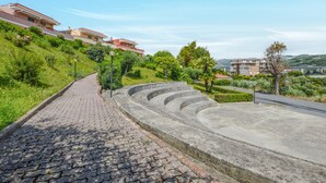 A paved pathway leading to a set of concrete steps with a view of residential buildings and greenery. - Lovely home in Pantai with WiFi (Pantai)