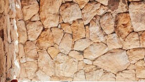 A stone wall, a bathtub, a bucket, and a glass of wine. - Pousada Vayú  (Amontada)