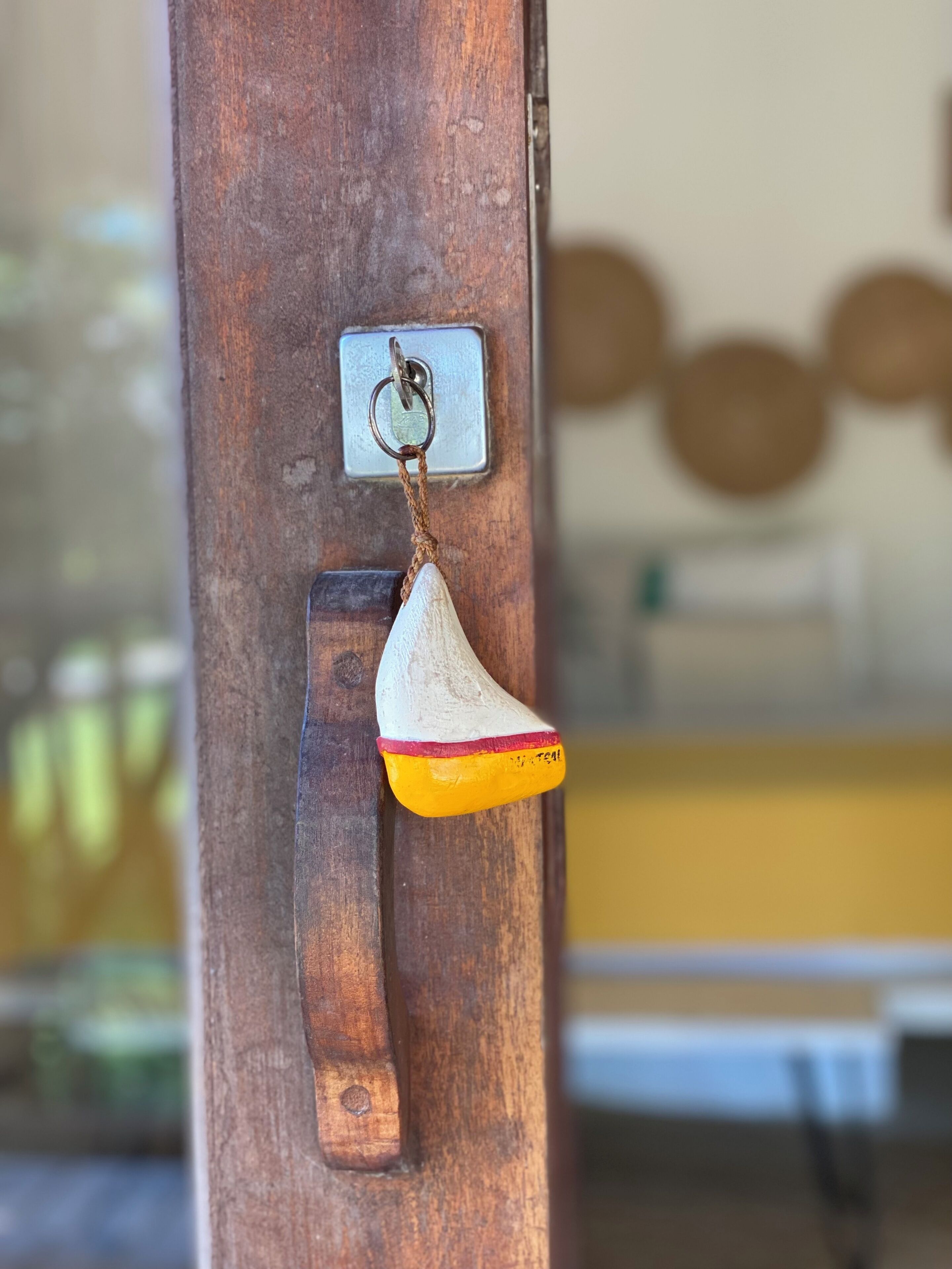 Una puerta de madera con un candado de metal y un llavero.