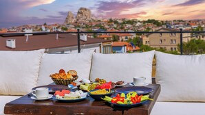 A table with breakfast items and a view of a cityscape at sunset.