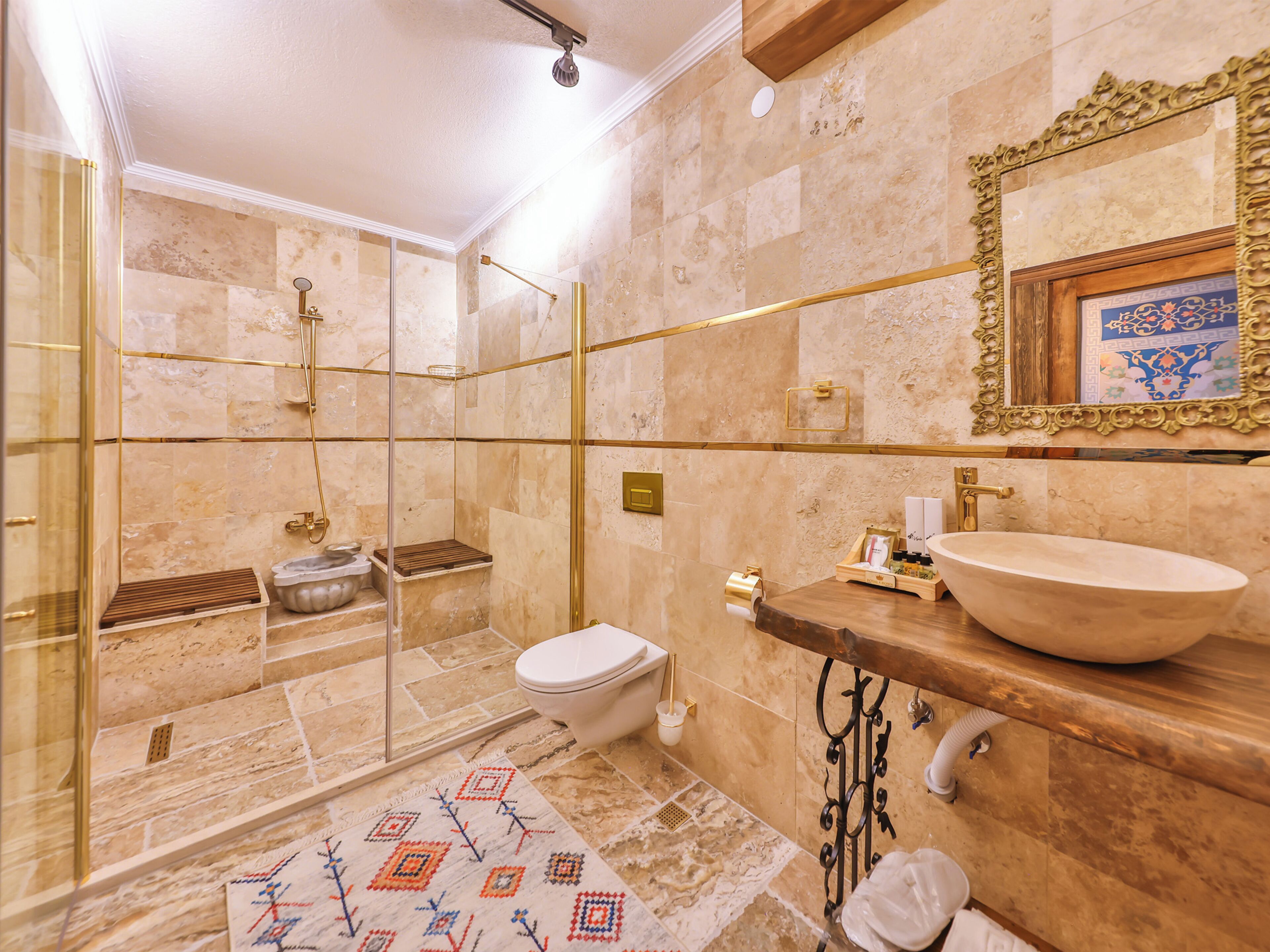Un bagno con doccia vetrata, un water e un ampio lavabo a vasca.