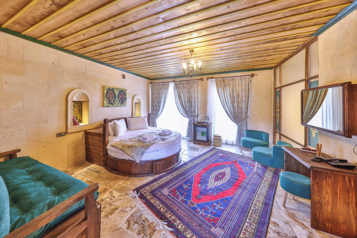 Una habitación con cama, escritorio, silla, alfombra y candelabro.