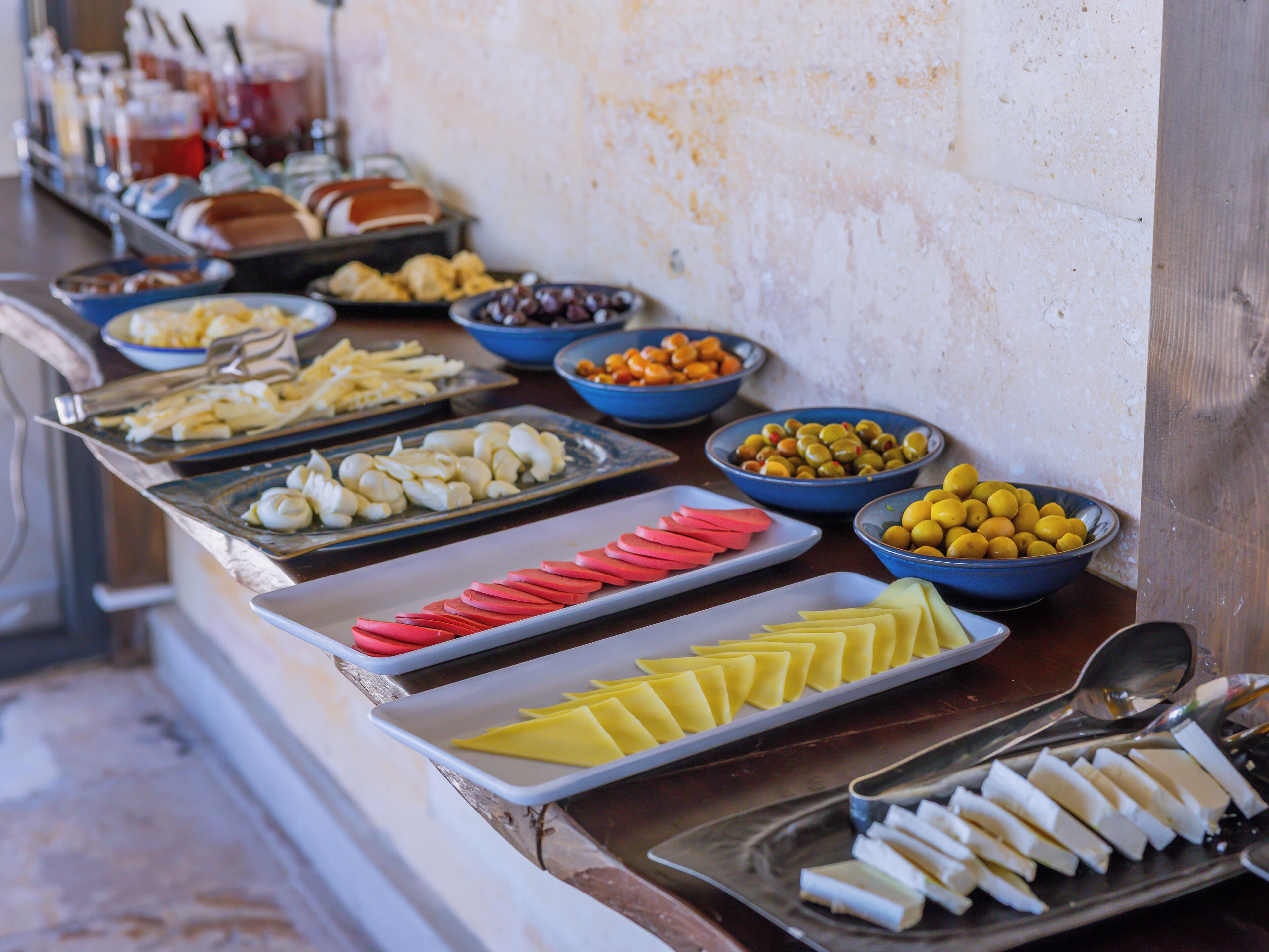 Buffet amb diversos aliments, com formatge, olives i verdures tallades.