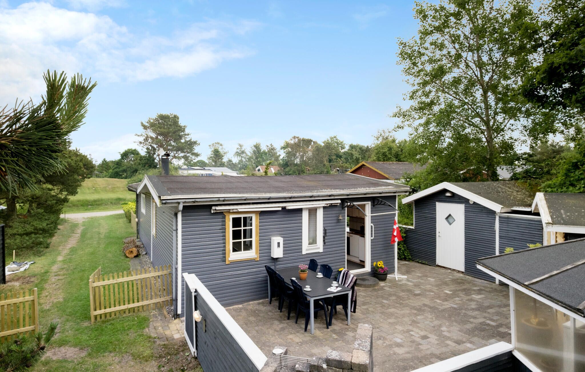 A small, single-story building with a patio area featuring a table and chairs.