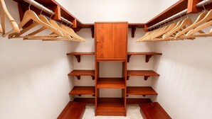 Un dressing avec des étagères en bois et des porte-manteaux.