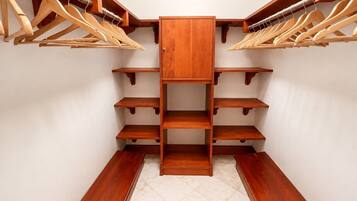A walk-in closet with wooden shelves and hangers.
