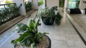 A lobby with a tiled floor, potted plants, and a staircase leading to an upper level. - Riviera: M4 Giardino 44A, Beach front (Bertioga)