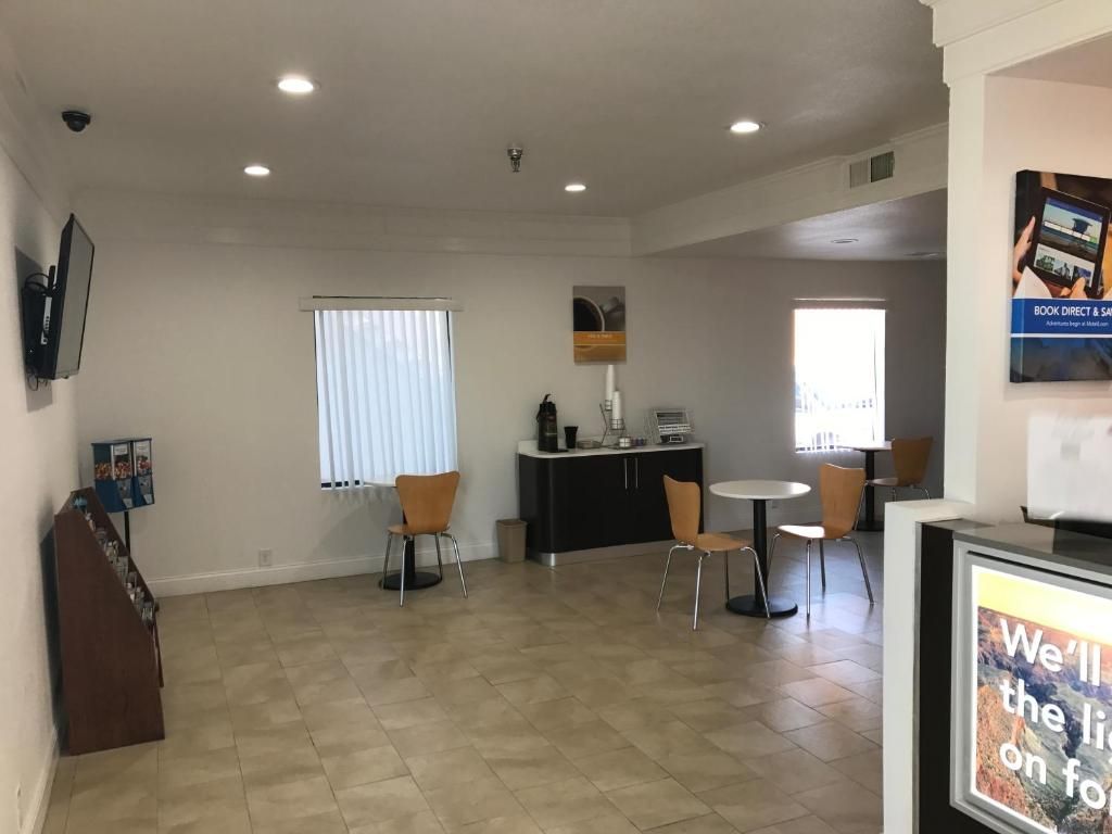 A spacious room with a dining area, a small kitchen, and a seating area with a view of the outdoors.