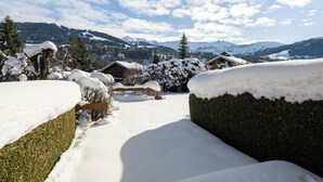 Un paysage enneigé, avec des maisons et des montagnes en arrière-plan.