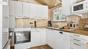 A modern kitchen with white cabinets, a built-in oven, a dishwasher, and a microwave. - 3 bedroom amazing home in Samsø (Samsø)