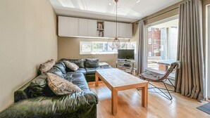 Una sala de estar moderna con un sofá modular, una mesa de centro de madera y un televisor.
