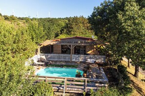 A house with a swimming pool, surrounded by a wooden deck and a white fence. - Lodge & piscine privée sur domaine viticole (Roquetaillade-et-Conilhac)