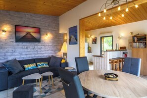 A modern living room with a sofa, chairs, a coffee table, and artwork on the walls.