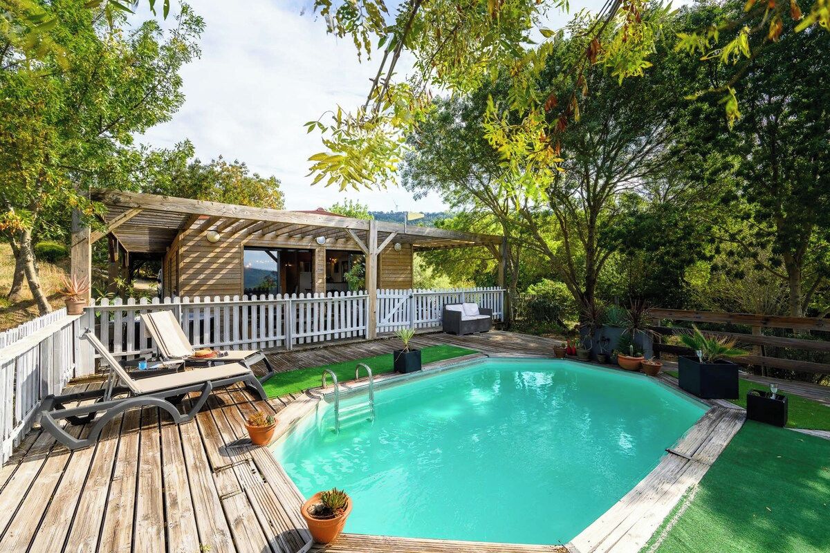 Une terrasse en bois avec une piscine, des chaises longues et un espace patio couvert.