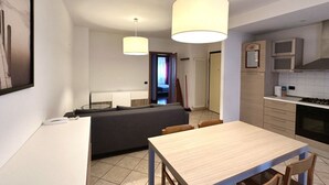 A modern kitchen with a dining table, a sofa, and pendant lights. - R003 - Recanati, delightful three-room apartment in the center (Recanati)