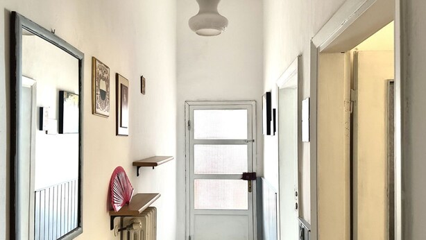 A narrow hallway with a white door, a radiator, and a mirror on the left wall. - SE096 - Senigallia, comfortable two-room apartment facing the sea (Senigallia)
