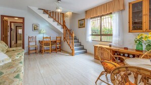 Un vaste espace de vie comprenant un escalier, des meubles en bois et une table à manger.