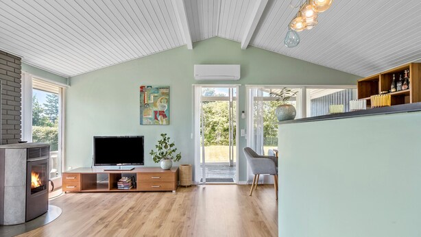 Un salon moderne doté d’une cheminée, d’un téléviseur et offrant une vue sur l’extérieur.