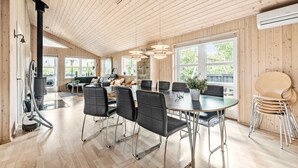 A spacious room with a large dining table, black chairs, and a modern kitchen area in the background. - Nice home in Tarm with sauna (Tarm)