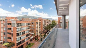 Un immeuble d’appartements moderne, doté de plusieurs étages, de balcons et offrant une vue dégagée sur le paysage environnant.