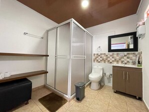 A bathroom with a shower, toilet, sink, and a mirror above the sink. - finca el arrullo (Armenia)