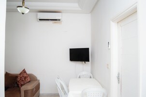 Apartamento básico, balcón | Zona de estar | Una televisión de pantalla plana