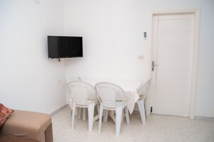 Apartamento básico, balcón | Zona de estar | Una televisión de pantalla plana