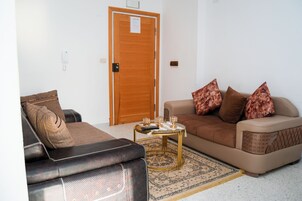 Apartamento básico, balcón | Zona de estar | Una televisión de pantalla plana