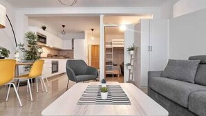 Ein modernes Wohnzimmer mit einer Couch, einem Couchtisch und einem Essbereich mit Stühlen.