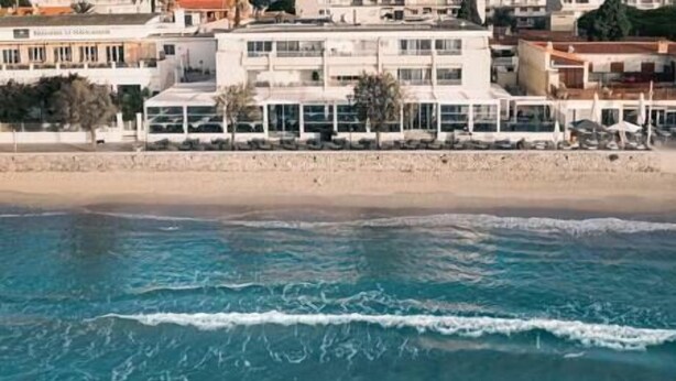 Ein Küstenhotel mit mehreren Balkonen mit Blick auf den Strand.