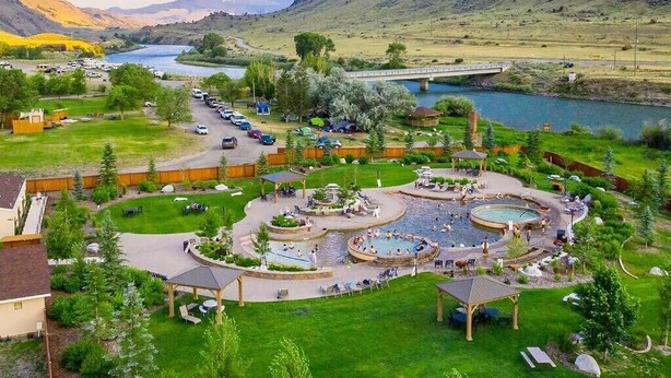 Un complexe hôtelier doté d’une piscine, d’un espace extérieur aménagé et offrant une vue sur une rivière et des montagnes.