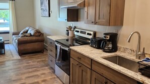 A modern kitchen with wooden cabinets, a stainless steel oven, and a built-in dishwasher.