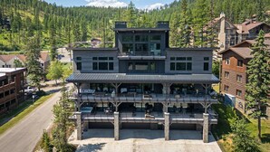 A multi-story hotel with a prominent central tower, large windows, and a spacious outdoor seating area.