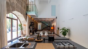 A modern kitchen with a gas stove, double sink, and a view of the living area. - Valverde Art Space by DomuSicily (Palermo)