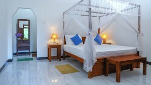 A bedroom with a four-poster canopy bed, two bedside tables with lamps, a wooden bench, and a green mat on the floor. - The Cattleya Guest House  (Sigiriya)