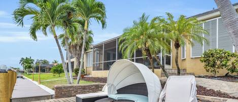 A patio with a curved seating area, a covered umbrella, and a stone pathway.