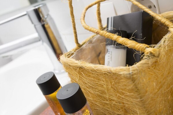 A wicker basket containing toiletries and a black box with a white label. - SingularStays Botanico Room Terrace III (Valencia)
