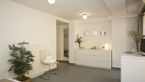 Une pièce moderne et bien éclairée, avec un bureau blanc, une chaise et une plante en pot.