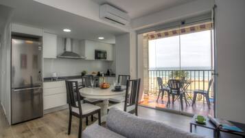 Eine moderne Küche mit Essbereich und einem Balkon mit Blick auf den Strand.