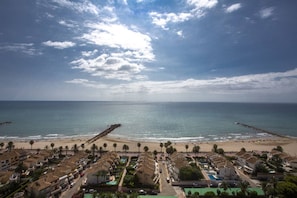 A coastal resort with beachfront villas, a pier, and a beach.
