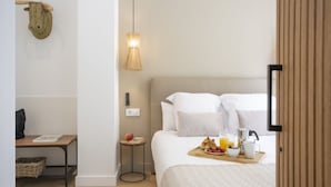 A bedroom with a bed, bedside table, lamp, and breakfast tray. - SingularStays Mercado Central IV (València)
