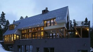 Un immeuble moderne à plusieurs étages, doté de grandes fenêtres et d’un balcon bien visible.