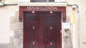 Une double porte en bois, au-dessus de laquelle on peut lire l’inscription « Mercado Central Apartments ».